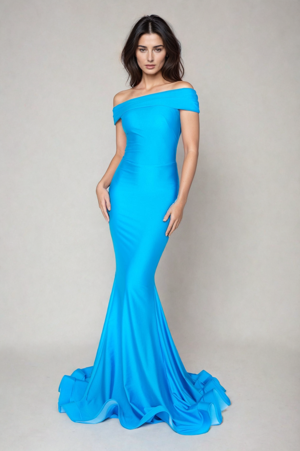 A woman stands against a plain light background wearing the Atria 6204H Off-Shoulder Long Mermaid Prom Dress in bright blue, featuring a form-fitting silhouette and mermaid hem.